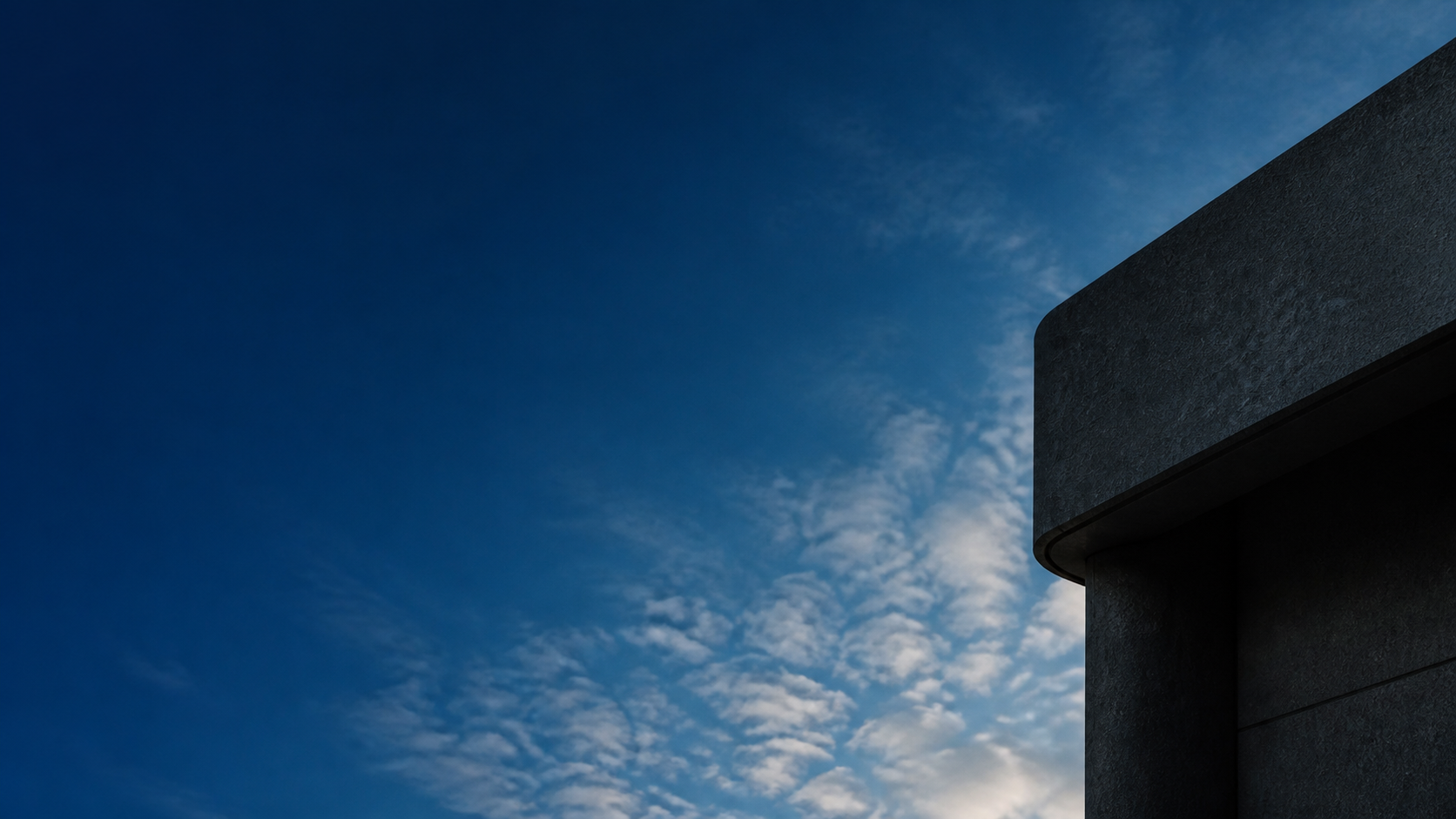 Deep blue sky beside a dark modern architectural form